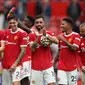 Gelandang Manchester United aau MU Bruno Fernandes (tengah) memegang bola pertandingan saat dia bereaksi dengan rekan setimnya usai laga melawan Leeds United pada pekan pertama Liga Inggris di Old Trafford, Sabtu, 14 Agustus 2021. (Adrian DENNIS / AFP)