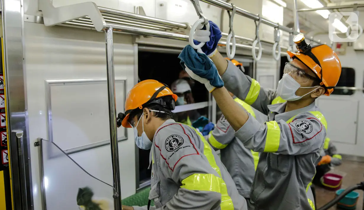 Petugas membersihkan handgrip bagian dalam pada rangkaian KRL Jabodetabek di Dipo Depok, Jawa Barat, Jumat (13/3/2020). Pembersihan bagian luar dan bagian dalam kereta menggunakan cairan disinfektan guna mengantisipasi penyebaran virus corona (Covid-19). (Liputan6.com/Faizal Fanani)