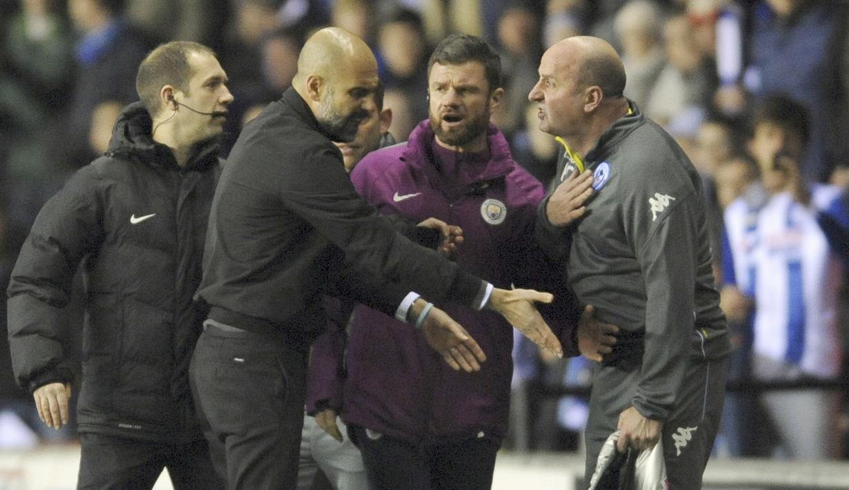 Pelatih Manchester City, osep Guardiola (2kiri) terlibat adu mulut dengan pelatih Wigan, Paul Cook pada laga babak kelima Piala FA di DW Stadium, Wigan, (19/2/2018). Manchester City kalah 0-1.  (AP/Rui Vieira)