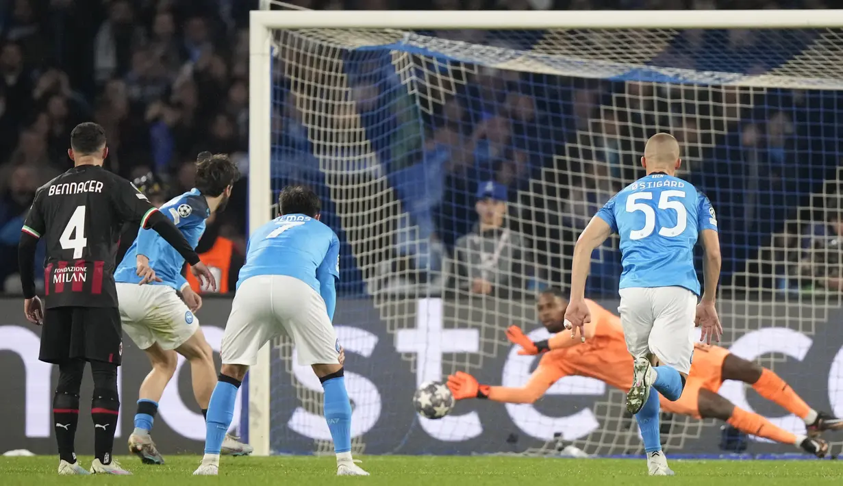 Kiper AC Milan, Mike Maignan, sukses menggagalkan tendangn penalti pemain Napoli, Khvicha Kvaratskhelia, pada laga babak perempat final leg kedua di Stadio Diego Armando Maradona, Rabu (19/4/2023). Meski meraih hasil imbang, Milan tetap lolos ke semifinal Liga Champions dengan kemenangan agregat 2-1 atas Napoli. (AP Photo/Andrew Medichini)
