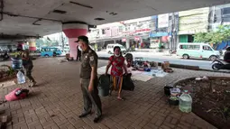 Petugas Satpol PP melakukan razia kepada para tunawisma di bawah flyover Jatinegara, Jakarta Timur, Senin (19/7/2021). Hal ini juga untuk mencegah terjadinya penyebaah virus Covid-19. (Liputan6.com/Johan Tallo)