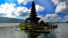 Warga yang naik perahu melintas dekat Pura Ulun Danu Beratan di Kecamatan Baturiti, Tabanan, Bali, Senin (24/04/2023). Sejumlah objek wisata di Pulau Dewata diserbu wisatawan domestik asal kota-kota besar di Pulau Jawa saat momen libur Idul Fitri 1444 Hijriah. (merdeka.com/Arie Basuki)