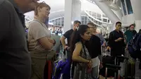Sejumlah penumpang mencari informasi jadwal penerbangan di Bandara Ngurah Rai, Bali, Jumat (29/6). PT Angkasa Pura I menutup sementara operasional bandara selama 16 jam dikarenakan dampak abu vulkanik Gunung Agung. (AP/Firdia Lisnawati)