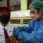 Seorang Siswa SDN 01 dan SDN 03 Jatinegara Kaum melakukan vaksinasi anak usia 6-11 tahun di Jakarta Timur, Selasa (14/12/2021). Sebanyak 6,4 juta dosis vaksin Sinovac akan digunakan dalam vaksinasi anak ini hingga akhir Desember 2021. (merdeka.com/Imam Buhori)