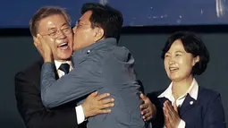 Kandidat Presiden Korsel, Moon Jae-in mendapat kecupan dari Gubernur Provinsi Chungcheong, Ahn Hee-jung sebelum menyampaikan pidato kemenangannya di Seoul, Selasa (9/5). Moon menang telak dengan megantongi 41,4 persen suara. (AP Photo/Ahn Young-joon)