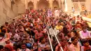 Umat Hindu duduk di tangga kuil Radha di kampung halaman legendaris Radha selama festival Lathmar holi di Barsana, India, Selasa (23/3/2021). Para umat akan merayakan festival ini dengan menari, bernyanyi dan membenamkan diri dalam warna sambil menikmati minuman tradisional thandai. (AP Photo)