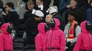 Orang-orang berpakaian seperti penjaga Squid Games dengan berdiri di area penonton selama pertandingan lanjutan Liga Inggris 2024/2025 antara Tottenham Hotspur melawan Liverpool di Stadion Tottenham Hotspur, London, Inggris Minggu (22/12/2024). Seperti diketahui, aksi tersebut ternyata merupakan promo musim kedua serial Korea Selatan tersebut. (AP Photo/Dave Shopland)