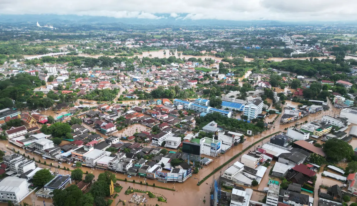 Foto udara yang diambil pada tanggal 12 September 2024 ini menunjukkan banjir mengepung rumah-rumah di kota Chiang Rai, Thailand utara. (Lillian SUWANRUMPHA/AFP)