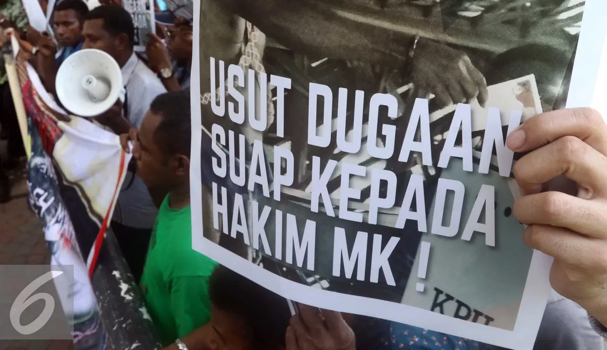 Warga Papua membawa beragam poster saat aksi di depan KPK, Jakarta, Senin (2/5). Mereka meminta KPK mengusut dugaan suap hakim MK di sengketa pilkada Teluk Bintuni (Liputan6.com/Helmi Afandi)