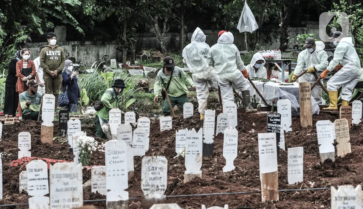 Petugas mengenakan APD lengkap saat proses pemakaman jenazah dengan protokol Covid-19 di TPU Bambu Apus, Jakarta, Kamis (28/1/2021). Pemprov DKI menyiapkan 6 lokasi baru untuk pemakaman jenazah pasien Covid-19 dengan total kapasitas 17.900 petak makam. (merdeka.com/Iqbal S Nugroho)