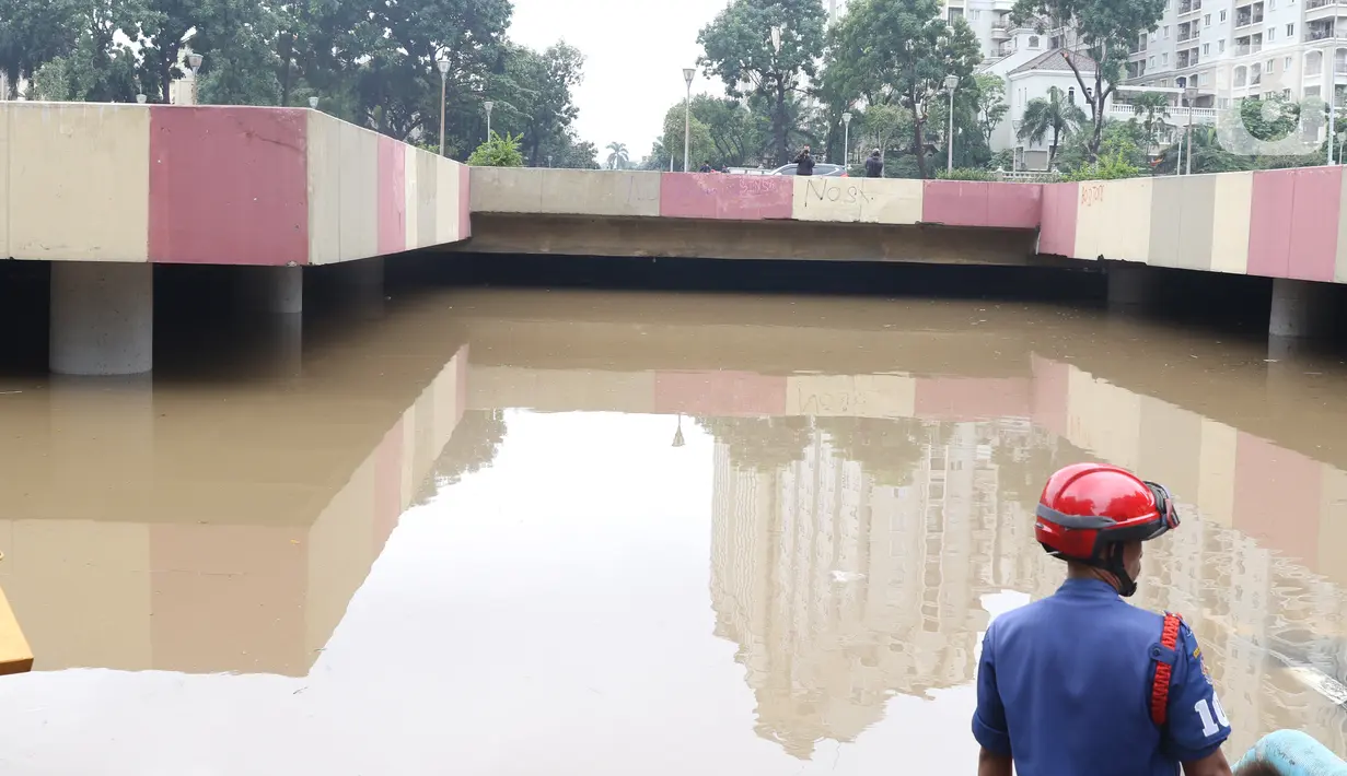 Petugas berada di dekat underpass Kemayoran yang terendam banjir di Jakarta, Minggu (2/2/2020). Banjir kembali merendam underpass Kemayoran, Jakarta Pusat. Akibatnya, akses jalur tersebut pun terputus alias tak bisa dilalui kendaraan. (Liputan6.com/Angga Yuniar)
