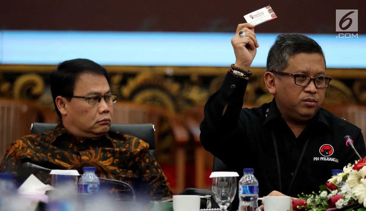 Sekjen PDI Perjuangan, Hasto Kristiyanto (kanan) menunjukkan kartu rekening gotong royong saat Diskusi dan Rencana Deklarasi Keterbukaan Informasi Publik Partai Politik di kantor DPP PDIP Jakarta, Rabu(28/3). (Liputan6.com/Johan Tallo)
