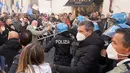 Demonstran bentrok dengan polisi Italia saat aksi protes oleh pemilik Restoran dan toko di luar lower Chamber di Roma, Selasa (6/4/202). Demonstran menuntut pembukaan kembali bisnis mereka dan memprotes tindakan pembatasan untuk mengatasi lonjakan kasus COVID-19. (AP Photo/Andrew Medichini)