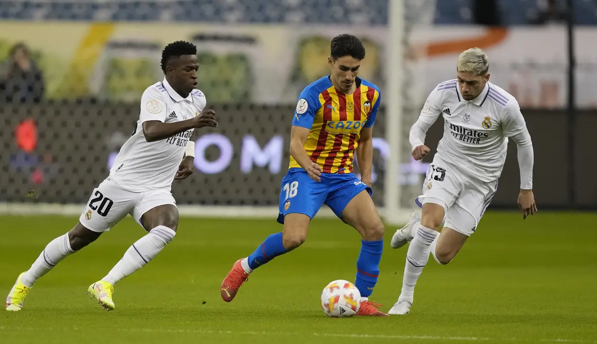 Bek Valencia, Andre Almeida berusaha mengumpan bola dari kawalan dua pemain Real Madrid, Vinicius Junior dan Federico Valverde pada pertandingan semifinal Piala Super Spanyol di Stadion Internasional King Fahd di Riyadh, Arab Saudi, Kamis (12/1/2023). Kemenangan tersebut membuat Los Blancos melaju ke final Piala Super Spanyol 2023. (AP Photo/Hussein Malla)