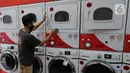 Pekerja membersihkan mesin cuci di gerai jasa layanan laundry, kawasan Kemang, Jakarta, Rabu (25/11/2020). Sejak tiga bulan terakhir omset mereka kembali membaik dan mengalami peningkatan sebesar 20 hingga 30 persen. (Liputan6.com/Herman Zakharia)