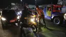 Petugas lalu lintas memeriksa suhu tubuh pengendara sepeda motor di pos pemeriksaan virus corona COVID-19 di Manila, Filipina, Senin (16/3/2020). Polisi beserta petugas lalu lintas dan petugas desa mengecek suhu tubuh warga untuk mencegah penyebaran virus corona COVID-19. (AP Photo/Aaron Favila)