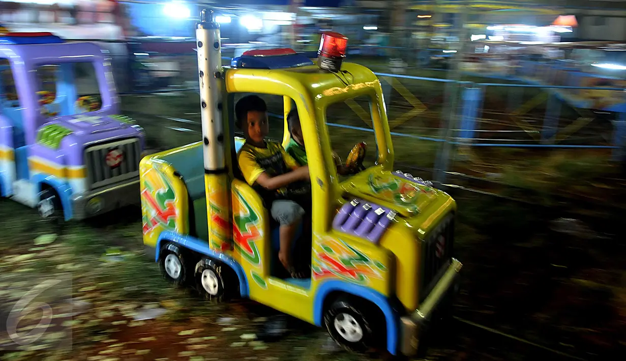 Warga bermain di wahana pada sebuah pasar malam yang digelar kawasan Pondok Aren, Tangerang Selatan, Senin (22/6/2015). Di tengah hingar bingar bisnis hiburan malam modern, keberadaan pasar malam masih banyak diminati warga. (Liputan6.com/Johan Tallo)