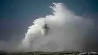 Ombak menghantam pemecah gelombang dan mercusuar pelabuhan Newhaven, saat Badai Eunice menghantam Newhaven, di pantai selatan Inggris, Jumat, 18 Februari 2022. (AP)