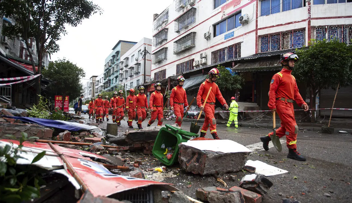 Petugas penyelamat berjalan di dekat puing-puing setelah gempa bumi di Kotapraja Fuji, Kabupaten Luxian di Provinsi Sichuan, China barat daya, Kamis (16/9/2021). (Jiang Hongjing/Xinhua via AP)