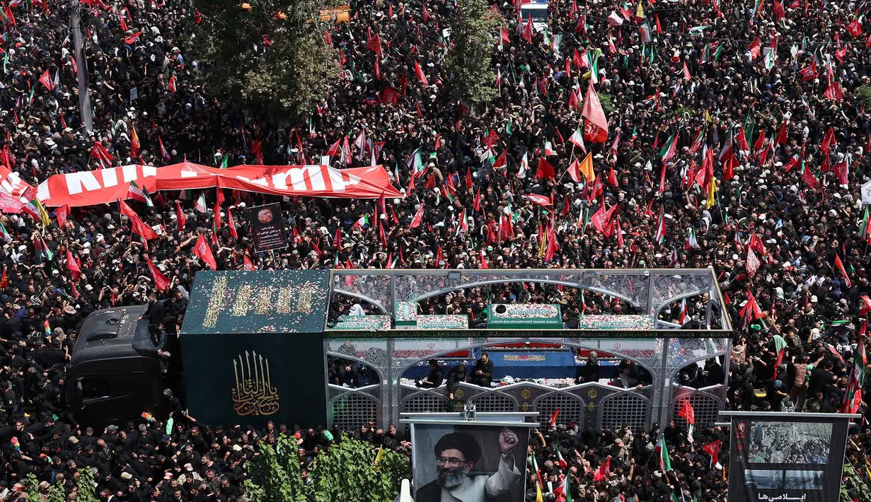 Sebuah truk yang membawa peti jenazah Pemimpin Tertinggi Iran Ayatollah Ali Khamenei dan anggota keluarganya melintas di tengah kerumunan pelayat selama prosesi pemakaman di Teheran, Iran, Senin, 6 Juli 2026. (AFP)