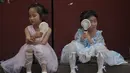 <p>Anak-anak mendinginkan diri dengan kipas angin listrik saat beristirahat dekat Kota Terlarang pada hari yang panas di Beijing, China, 25 Juni 2023. Beijing meningkatkan level peringatan cuaca panas menjadi level tertinggi, yaitu kode merah. (AP Photo/Andy Wong)</p>