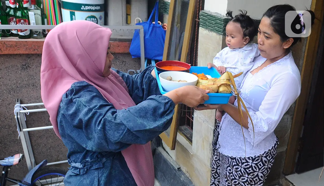 Umat Muslim mengantarkan makanan ketupat di kawasan Perumahan Pondok Kampial Permai, Nusa Dua, Bali, Jumat (21/04/2023). Momen Idul Fitri dimanfaatkan warga untuk saling tolong menolong sebagai semangat toleransi beragama. (merdeka.com/Arie Basuki)