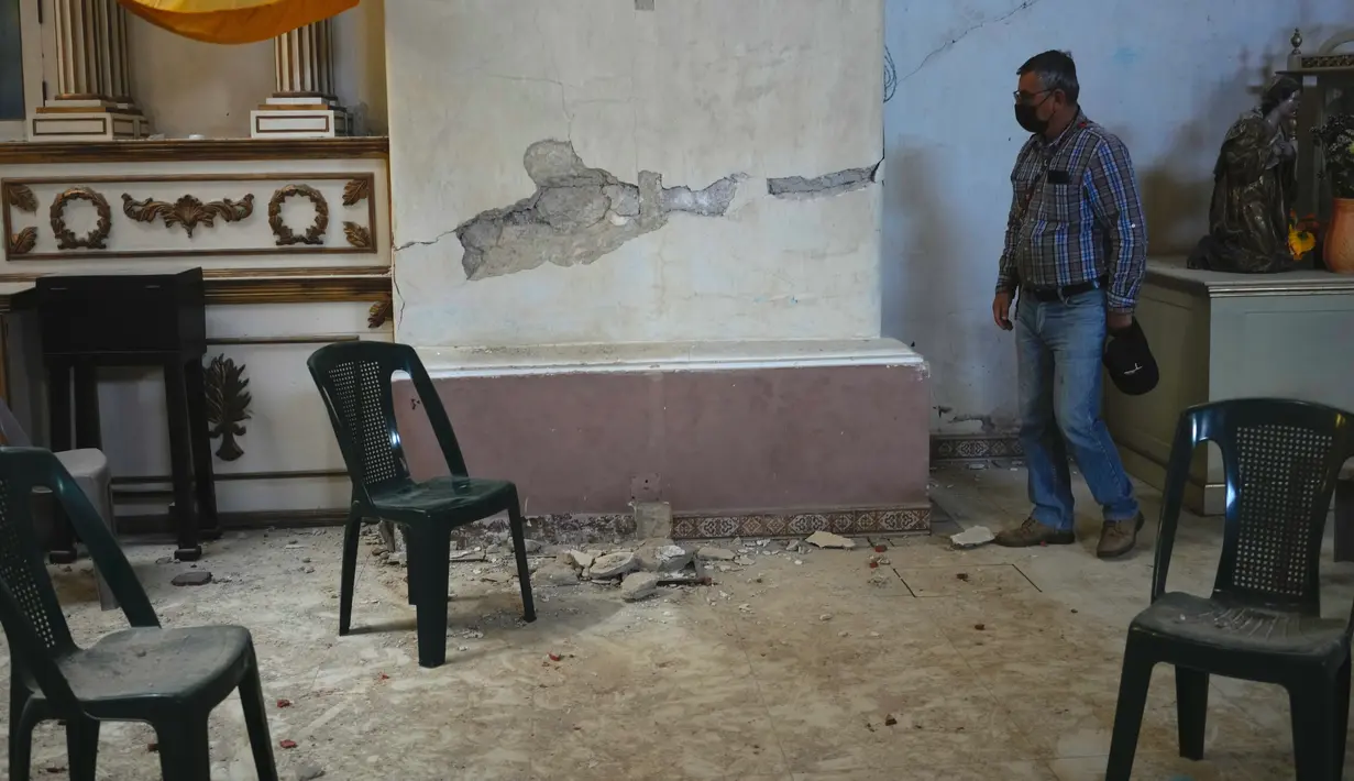 Seorang umat paroki mengunjungi gereja San Juan Bautista yang rusak akibat gempa bumi berkekuatan 6,2 skala Richter semalam di Amatitlan, Guatemala, 16 Februari 2022. Gempa bumi menyebabkan kerusakan yang mempengaruhi hampir 25.000 orang. (AP Photo/Moises Castillo)