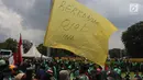 Pengemudi ojek online membawa bendera kuning saat melakukan aksi di seberang Istana Merdeka, Jakarta, Selasa (27/3). Dalam aksinya mereka menuntut pemerintah melakukan penetapan tarif standar dengan nilai yang wajar. (Liputan6.com/Arya Manggala)