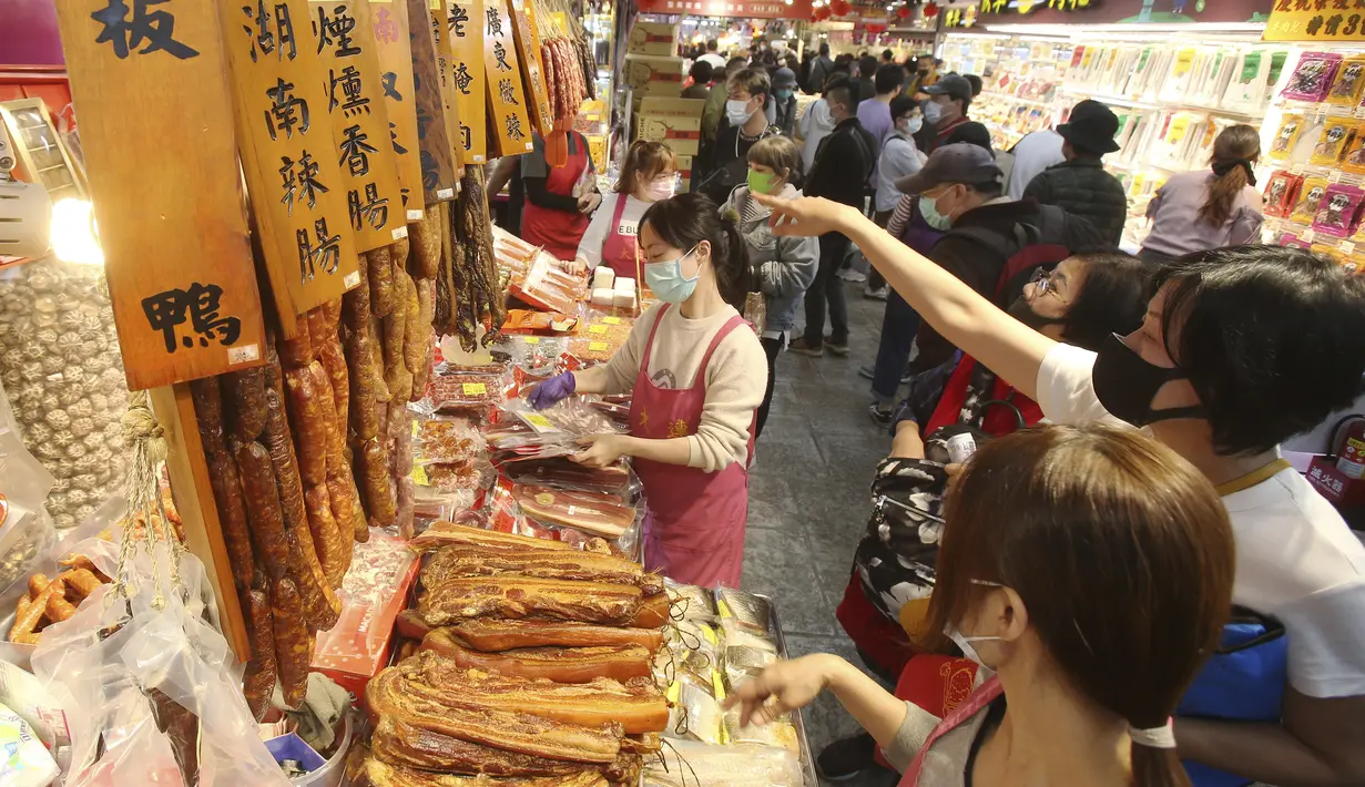 Warga mengenakan masker untuk mencegah penyebaran virus corona berbelanja untuk perayaan Tahun Baru Imlek di pasar Dihua Street di Taipei, Taiwan, Rabu (10/2/2021). Tahun Baru Imlek menurut kalender lunar akan berlangsung pada 12 Februari. (AP Photo/Chiang Ying-ying)