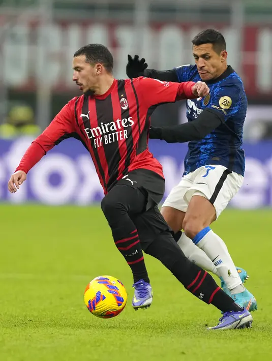 <p>Pemain AC Milan Ismael Bennacer (kiri) berebut bola dengan pemain Inter Milan Alexis Sanchez pada pertandingan leg pertama semifinal Coppa Italia di Stadion San Siro, Milan, Italia, 1 Maret 2022. Pertandingan berakhir imbang 0-0. (AP Photo/Antonio Calanni)</p>