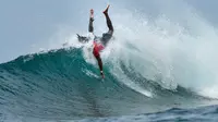 Seorang peselancar melakukan manuver saat kejuaraan Aceh Surfing Championship 2019 di Pantai Babah Kuala, Lhoknga, Aceh Besar, Sabtu (23/11/2019). Aceh Surfing Championship ini digelar selama dua hari untuk mempromosikan wisata Aceh, terutama wisata lautnya. (CHAIDEER MAHYUDDIN / AFP)