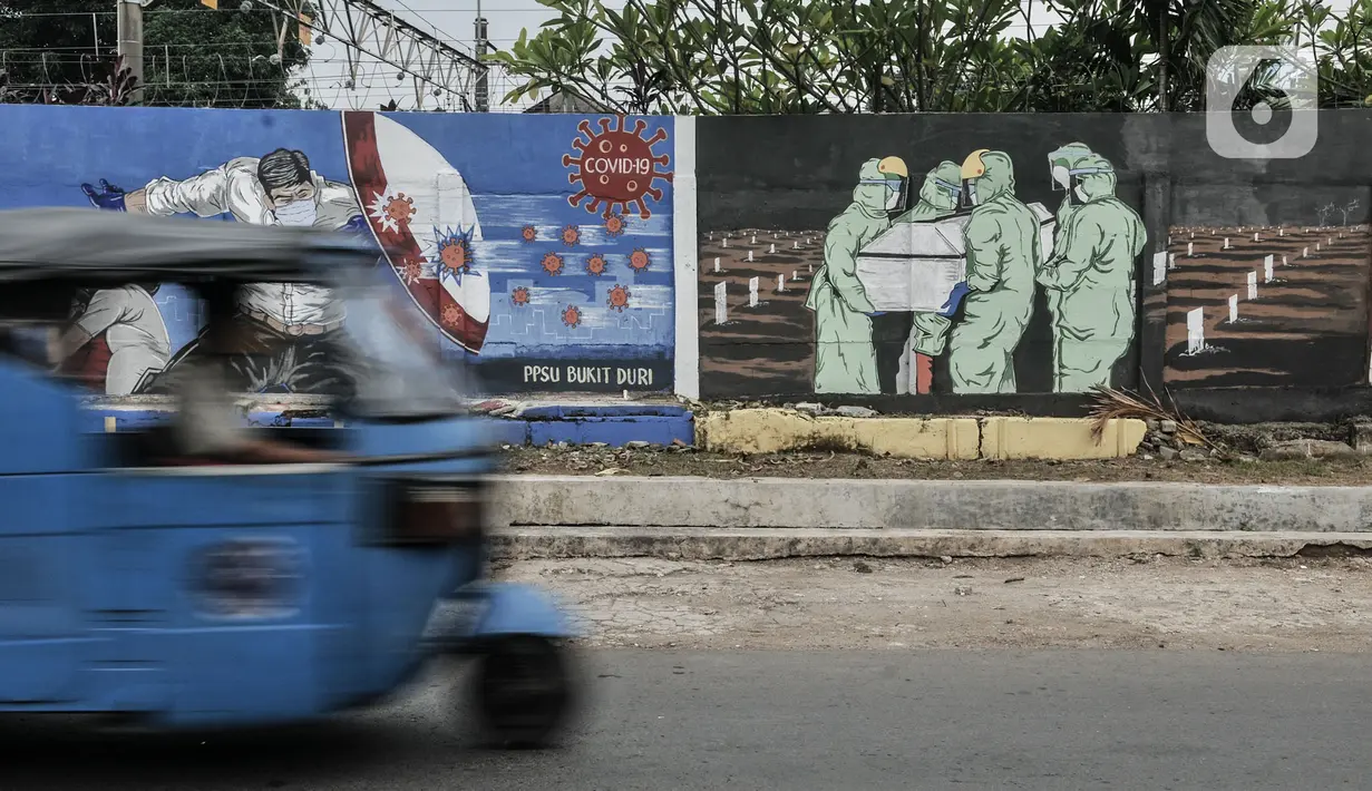 Kendaraan melintasi mural bertemakan Imbauan Protokol Kesehatan Covid-19 di kawasan Bukit Duri, Jakarta, Minggu (25/10/2020). Gubernur DKI Anies Baswedan kembali memperpanjang pelaksanaan PSBB masa transisi sebagai antisiapsi lonjakan kasus virus corona Covid-19. (merdeka.com/Iqbal Nugroho)