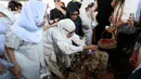 Usai jenazah dimakamkan, Dewi Yull ikut menabur bunga dan menyiram air mawar ke makam Ray Sahetapy sambil melantunkan doa. (KapanLagi.com/Budy Santoso)