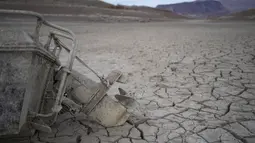 Sebuah perahu yang sebelumnya tenggelam berada di atas tanah retak ratusan kaki dari garis pantai Danau Mead di area rekreasi Danau Mead dekat Boulder City, negara bagian Nevada, pada Selasa, 10 Mei 2022. Danau Mead, salah satu waduk terbesar di AS, yang selama ini digunakan sebagai waduk dan tempat penampungan air kondisinya mengering. (AP Photo/John Locher)