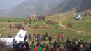 Sejumlah orang berkumpul di dekat jatuhnya pesawat kecil milik Kasthamandap Airlines di wilayah pegunungan bagian barat Nepal, Jumat (26/2). Pesawat yang membawa 11 orang itu jatuh ketika hendak melakukan pendaratan darurat. (REUTERS/Kamal Bahadur Shahi)