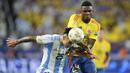 Bek Timnas Argentina, Lisandro Martinez (kiri) berusaha menghalau bola di depan striker Timnas Kolombia, Jhon Cordoba pada laga final Copa America 2024 di Hard Rock Stadium, Florida, Amerika Serikat, Minggu (14/7/2024). (AP Photo/Julio Cortez)