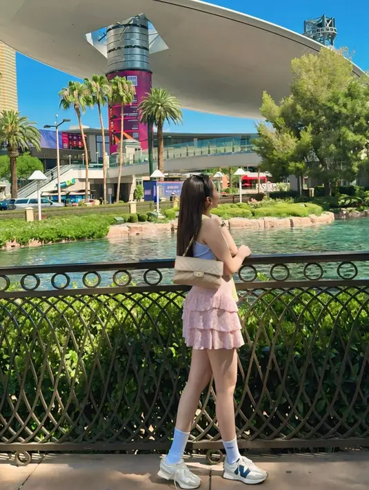 Penampilannya dilengkapi dengan shoulder bag Chanel dan sneakers New Balance warna beige senada. Cardigan yang dililitkan di leher menambah kesan stylish pada look kasual feminin Ayu. [@shandyaulia].