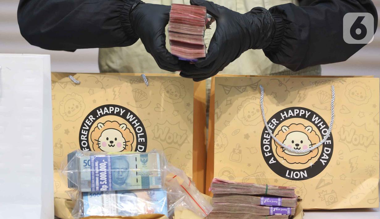 Petugas menunjukkan barang bukti berupa uang tunai yang disita dari Operasi Tangkap Tangan (OTT) terhadap Bupati Cilacap, Jawa Tengah, Syamsul Auliya Rachman, di Gedung Merah Putih Komisi Pemberantasan Korupsi (KPK), Jakarta, Sabtu (14/3/2026). (Liputan6.com/Helmi Fithriansyah)