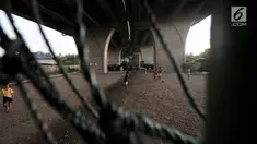 Anak-anak bermain sepak bola di kolong jalan Tol Lingkar Utara, Kalibaru, Cilincing, Jakarta, Kamis (28/3). Pemkot Jakarta Utara akan membangun Taman Maju Bersama (TMB) di kolong tol tersebut untuk mengurangi ruang kumuh serta menjadi sarana rekreasi warga dan anak-anak (merdeka.com/Iqbal S Nugroho)