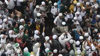 Sekelompok orang saat mengintimidasi hingga memukul para jurnalis yang tengah meliput aksi 112 di Masjid Istiqlal, Jakarta Pusat. (Liputan6.com/Herman Zakharia)