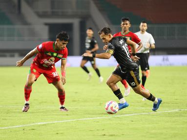 Egy Maulana Vikri (kanan) mencoba melewati Riswan Lauhin dalam pertandingan Dewa United melawan Persebaya Surabaya pada pekan ke-24 BRI Liga 1 di Stadion Pakansari, Kabupaten Bogor, Jumat (21/2/2025) malam WIB. (Bola.com/Abdul Aziz)