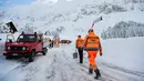 Petugas membawa sekop untuk membersihkan longsoran salju yang masuk ke dalam Hotel Saentis di Schwaegalp, Swiss, Jumat (11/1). (Gian Ehrenzeller/Keystone via AP)