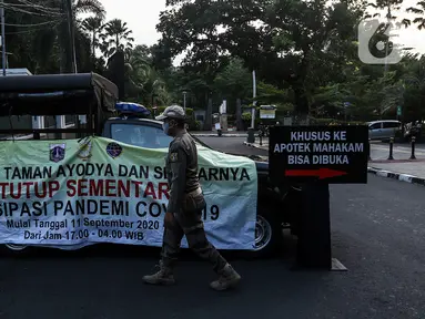 Petugas menutup area kawasan Taman Ayodya, Jalan Bulungan dan Mahakam, Jakarta, Rabu (23/9/2020). Penutupan jalan dilakukan agar masyarakat tidak berkumpul di area tersebut pada waktu malam hari dan menekan angka penularan virus corona COVID-19. (Liputan6.com/Johan Tallo)