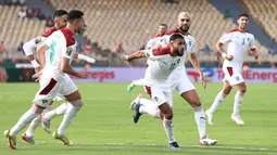 Maroko bahkan mampu unggul terlebih dahulu saat laga baru berjalan enam menit. Sofiane Boufal (tengah) yang ditunjuk sebagai algojo penalti sukses melesatkan bola ke gawang Abou Gabal. Maroko berhasil unggul 1-0 dan bertahan hingga turun minum. (AFP/Kenzo Tribouillard)
