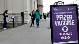 Orang-orang berdiri di luar pusat vaksinasi yang didirikan di Melbourne Exhibition Building di Melbourne mengumumkan lockdown (penguncian) untuk keenam kalinya di kota itu dalam upaya untuk menghentikan penyebaran Covid-19 varian delta, pada Kamis (5/8/2021).  (Con Chronis/AFP)