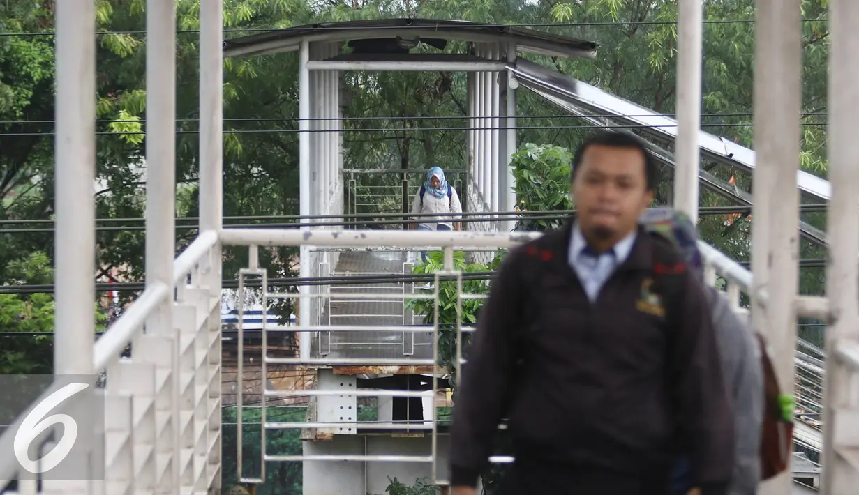 Warga melintasi Jembatan Penyeberangan Orang di kawasan Tanjung Barat, Jakarta, Jumat (11/11).Buruknya desain menyebabkan JPO tersebut tidak tersambung, sehingga warga harus membeli tiket kereta jika ingin menyeberang. (Liputan6.com/Immanuel Antonius)