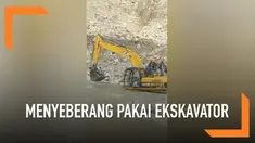 Warga India menyelamatkan diri dari bencana tanah longsor. Mereka menyeberangi sungai menggunakan ekskavator.