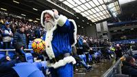 Sinterklas biru memegang bola sebelum dimulainya pertandingan Premier League Inggris antara Everton dan Chelsea di Goodison Park, Liverpool, Inggris barat laut, pada 22 Desember 2024. (Paul ELLIS/AFP)