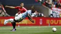 Winger Manchester City, Jeremy Doku mendapatkan gangguan dari bek sayap Manchester United, Diogo Dalot dalam laga Community Shield di Wembley, Sabtu (10/8/2024) malam WIB. (AP Photo/David Cliff)