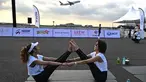 Sekitar 500 peserta yoga dan influencer yang siap dengan kamera mulai berdatangan pada pukul 5:00 pagi, berjalan dalam kegelapan menuju matras mereka di landasan pacu. (MANAN VATSYAYANA / AFP)
